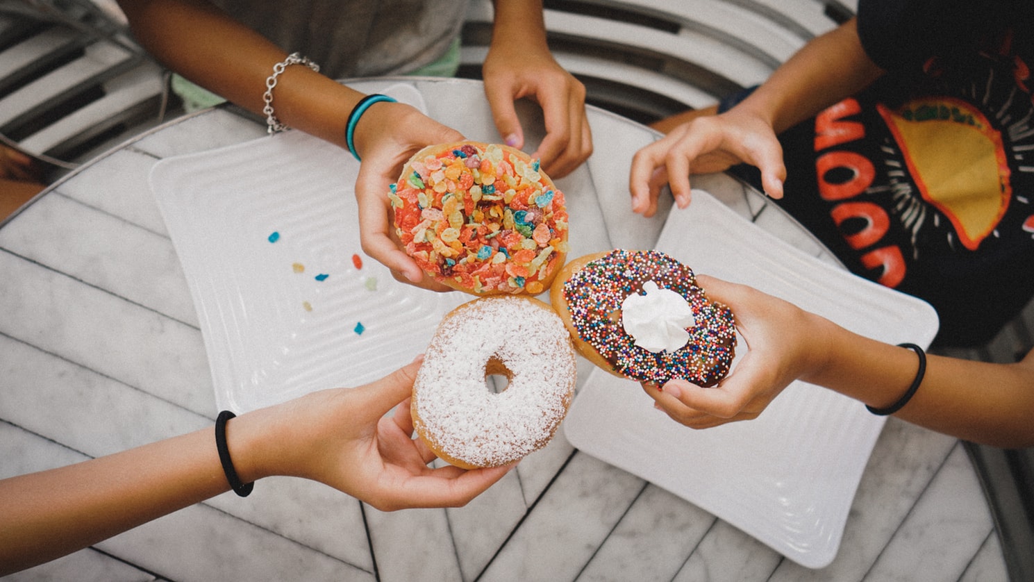 Trzy dziewczyny trzymają pączki